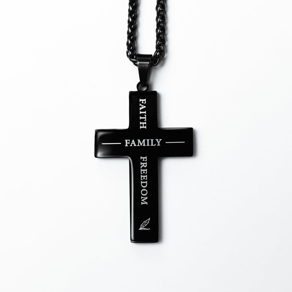 Black cross pendant necklace with engraved text on a white background